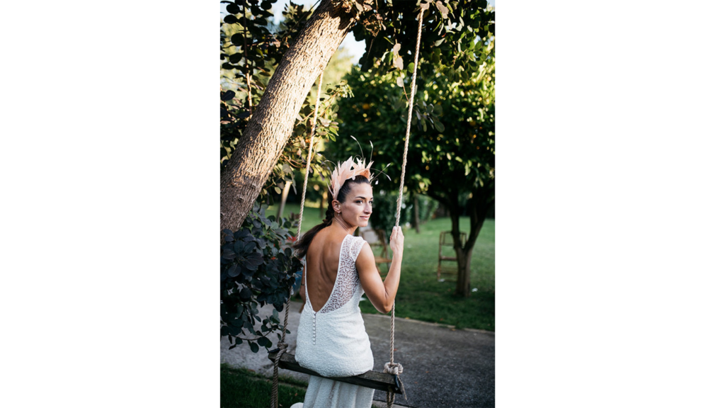 Itziar Mangana con el look nupcial que eligió para el día de su boda en Jardín de Barretaguren. Un precioso vestido diseñado por Alicia Rueda y con una espectacular espalda descubierta que combinó con  un tocado de plumas de Anita Ribbon.